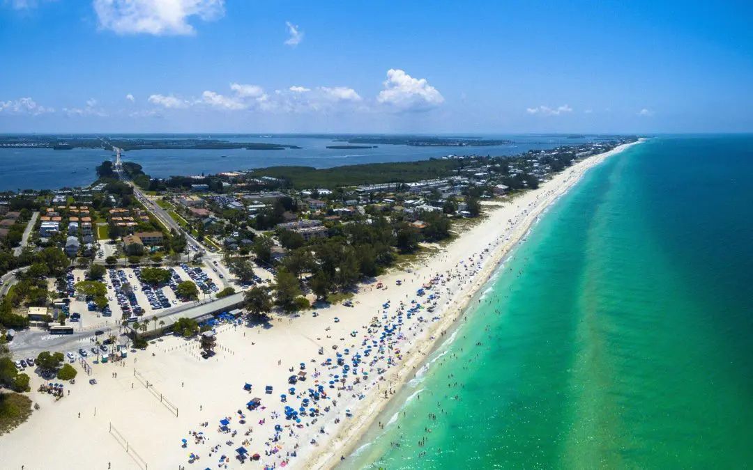 An aerial view of a beach filled with people on a sunny day.