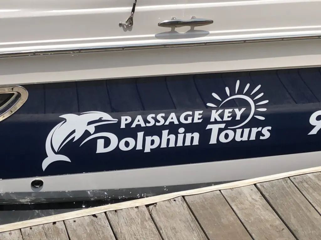 a boat with logo passage key dolphin tours