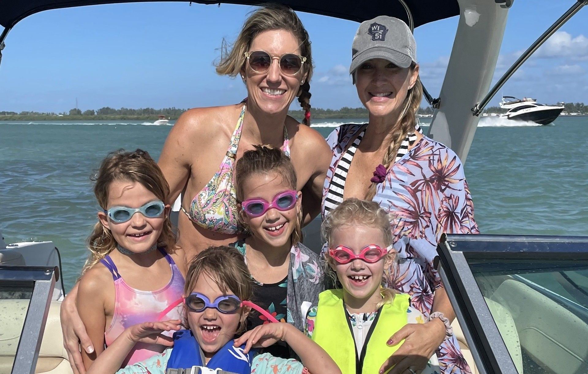 A group of women and children are posing for a picture on a boat.