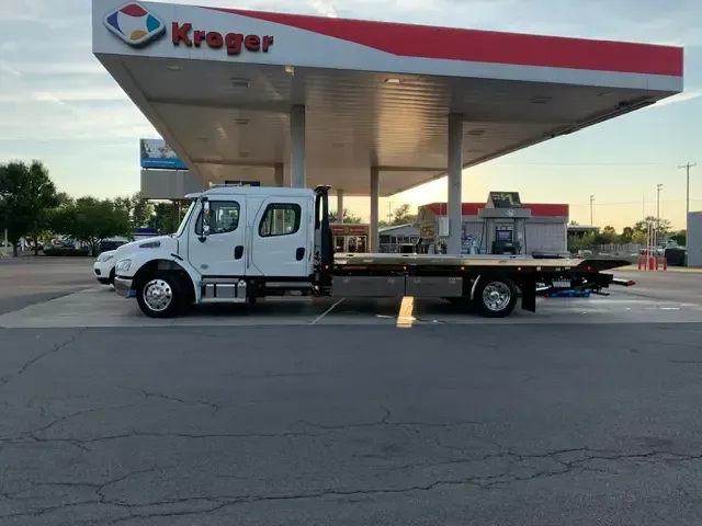 Tow truck parked at a Kroger gas station under a white canopy.