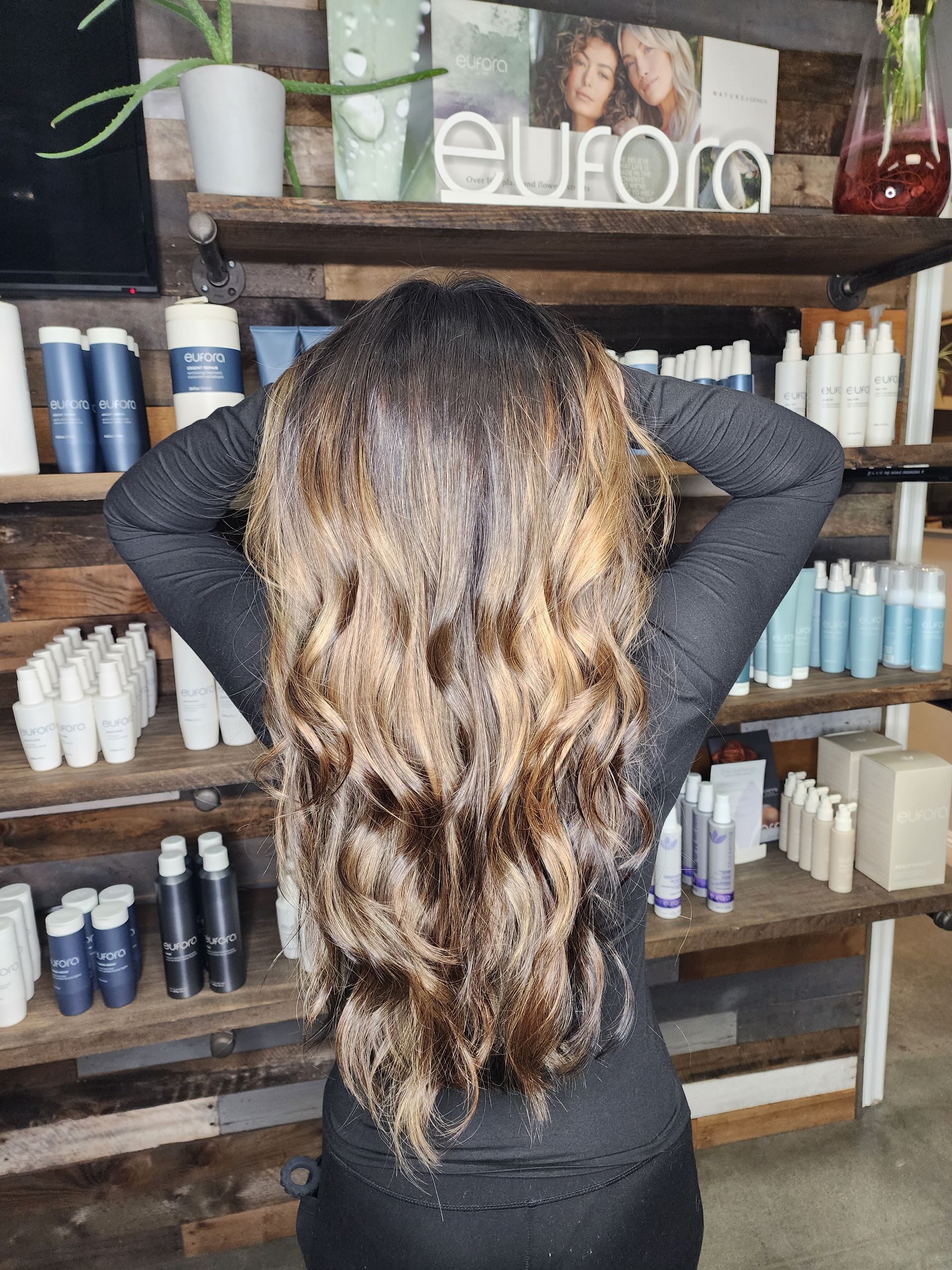Woman with a short, black, stacked bob haircut; wearing a blue shirt.
