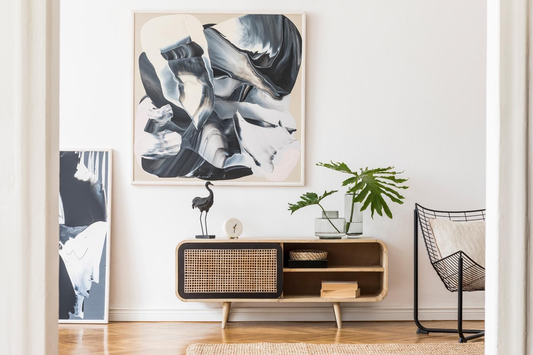 A living room with a painting on the wall and a dresser.