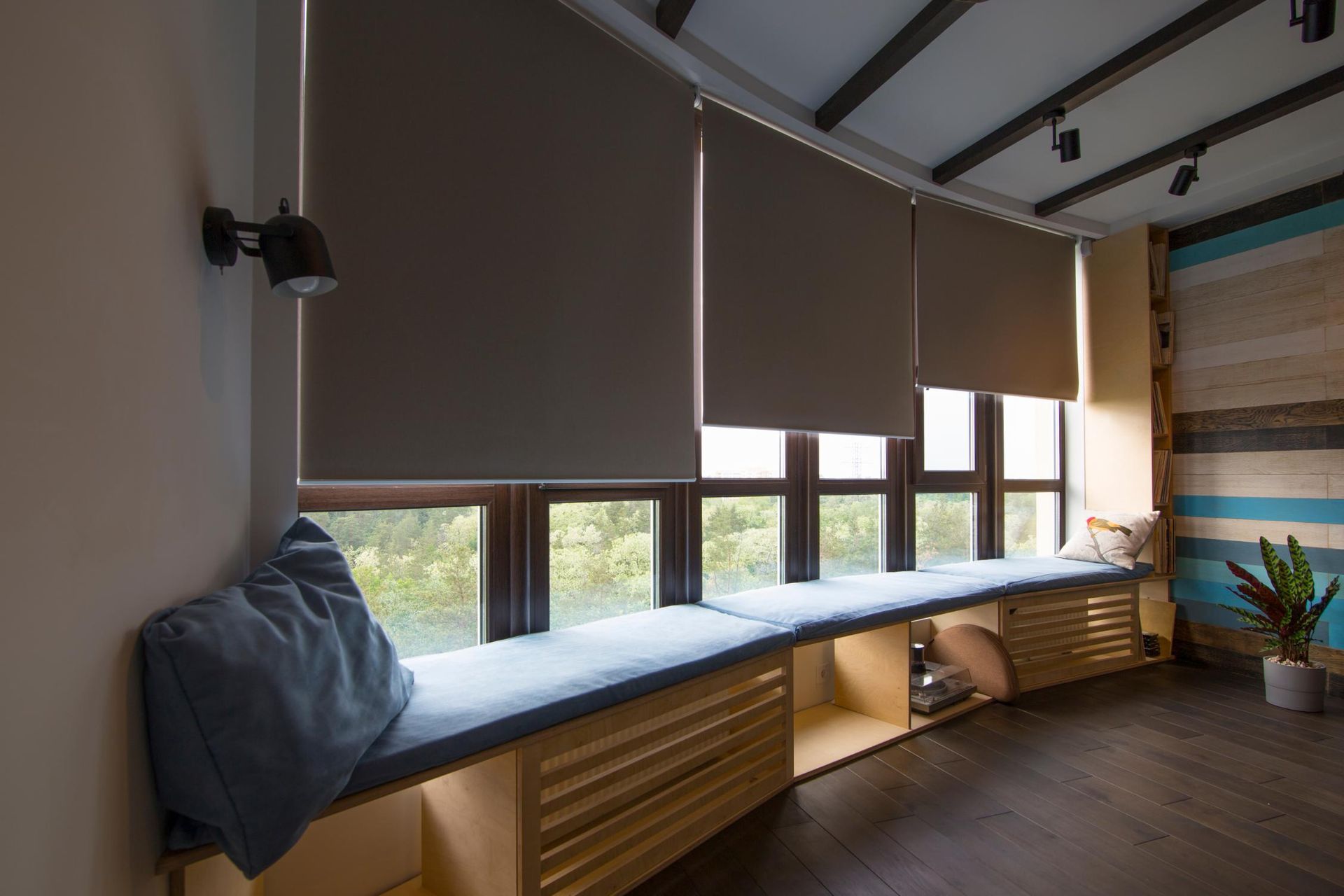 A living room with a window seat and lots of windows.