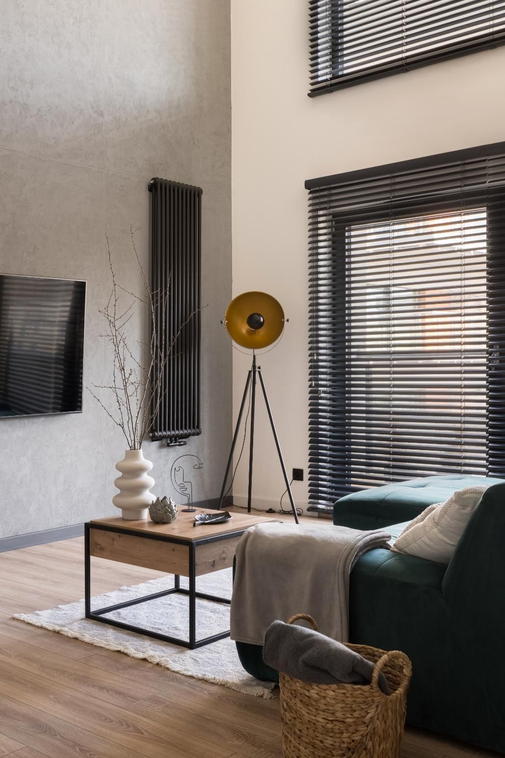 A living room with a couch, coffee table, lamp and television.