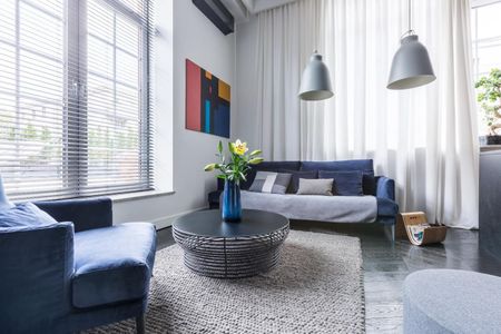 A living room with a couch, chairs, and a coffee table.