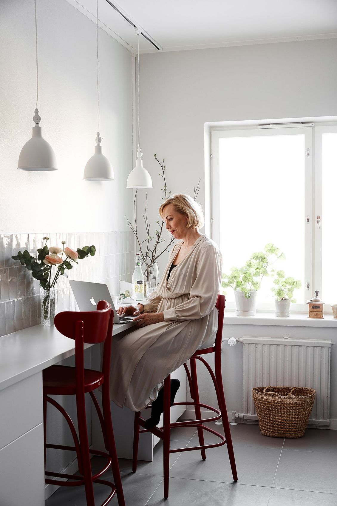 Hanna Velling istuu keittiössä tietokoneen ääressä ikkunan edessä. Kuva: Krista Keltanen