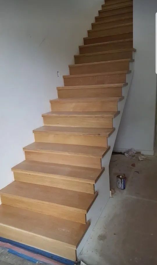 A wooden staircase is being built in a house