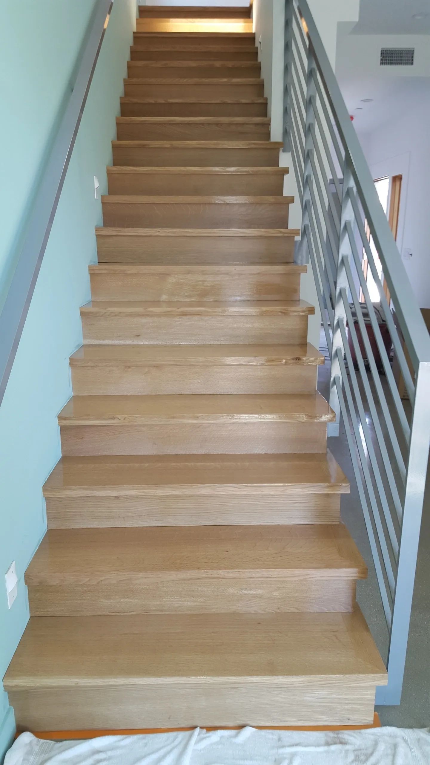 A wooden staircase with a metal railing in a house