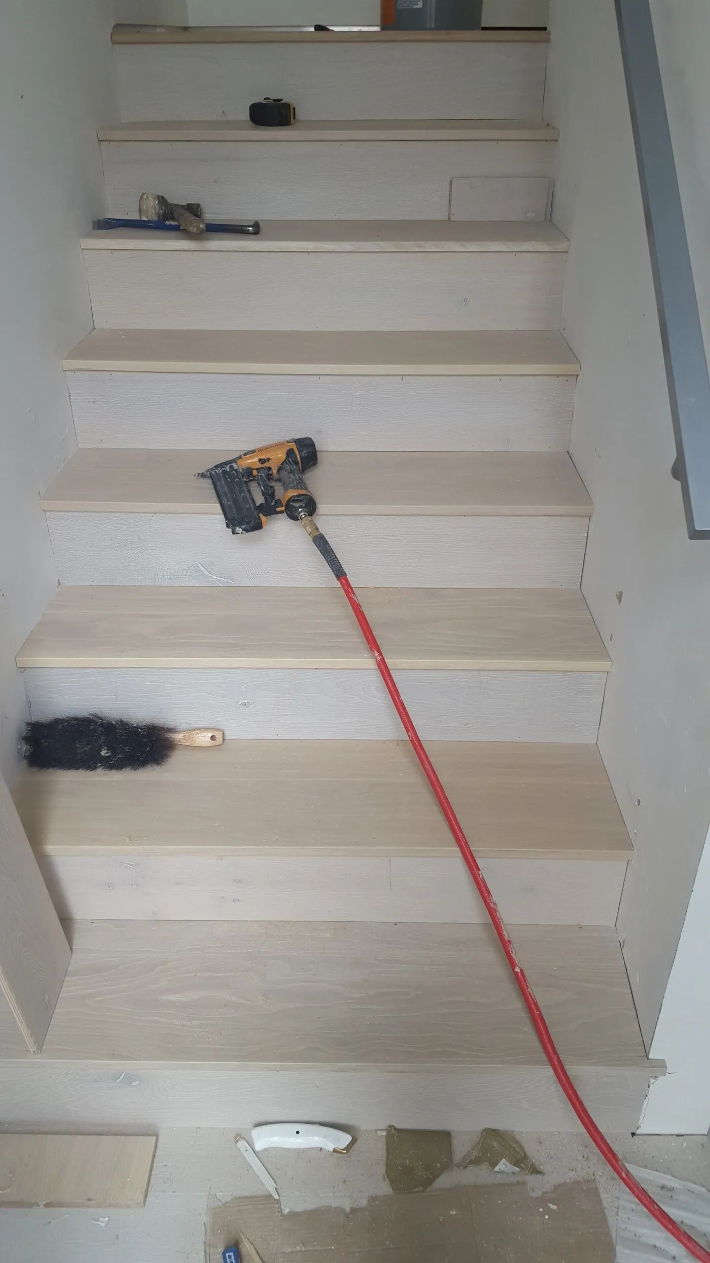 A set of stairs being built with a drill and a broom