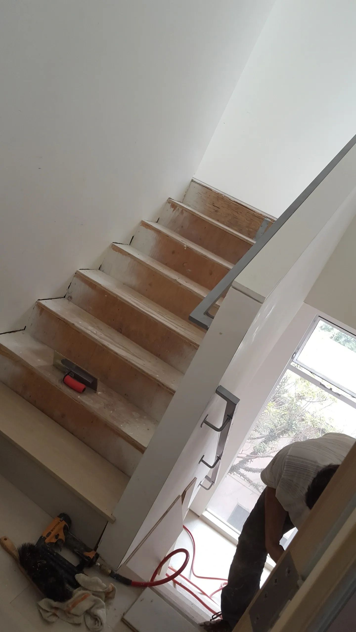 A man is working on a staircase in a house
