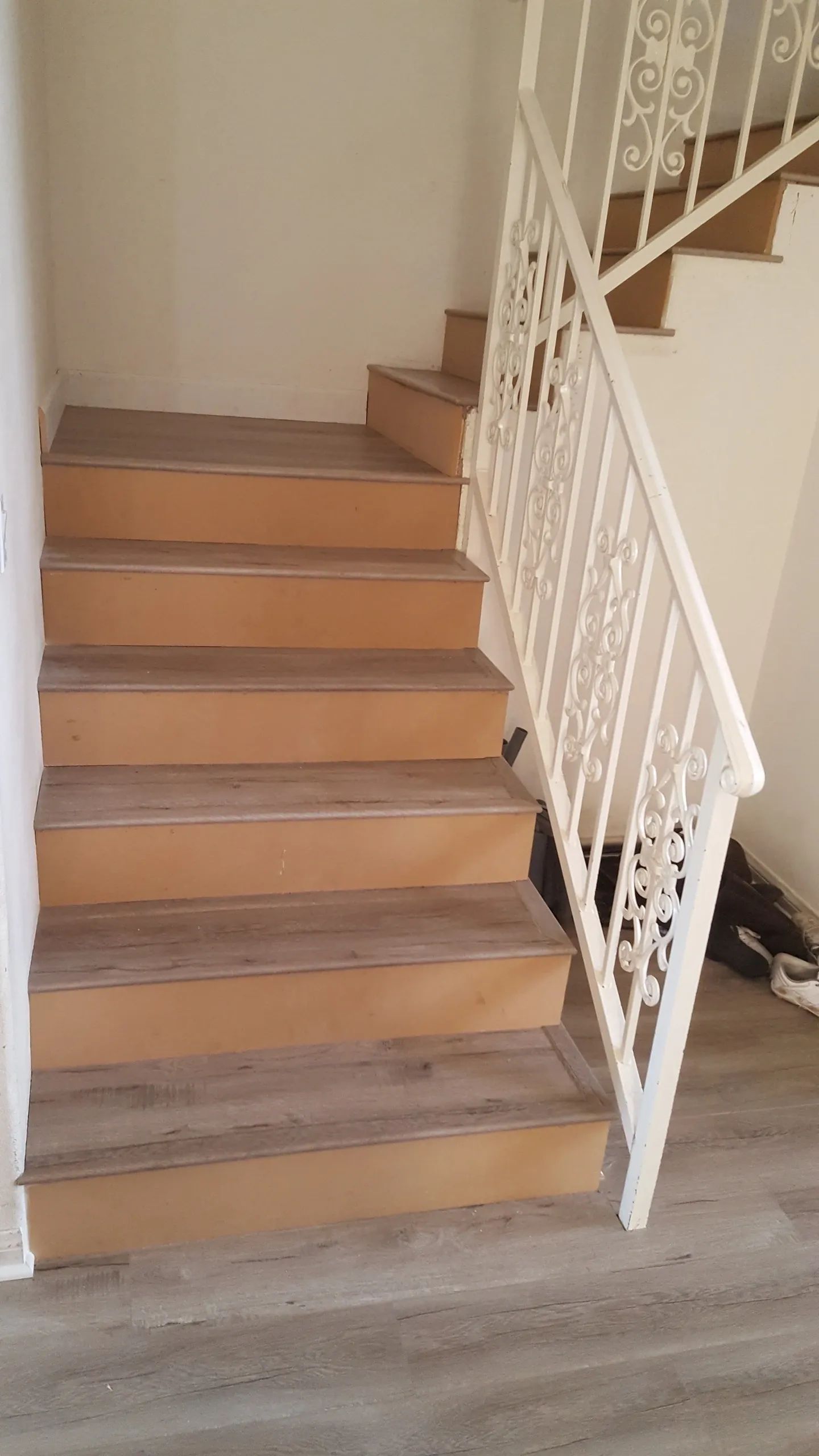 A staircase with wooden steps and a white railing in a house