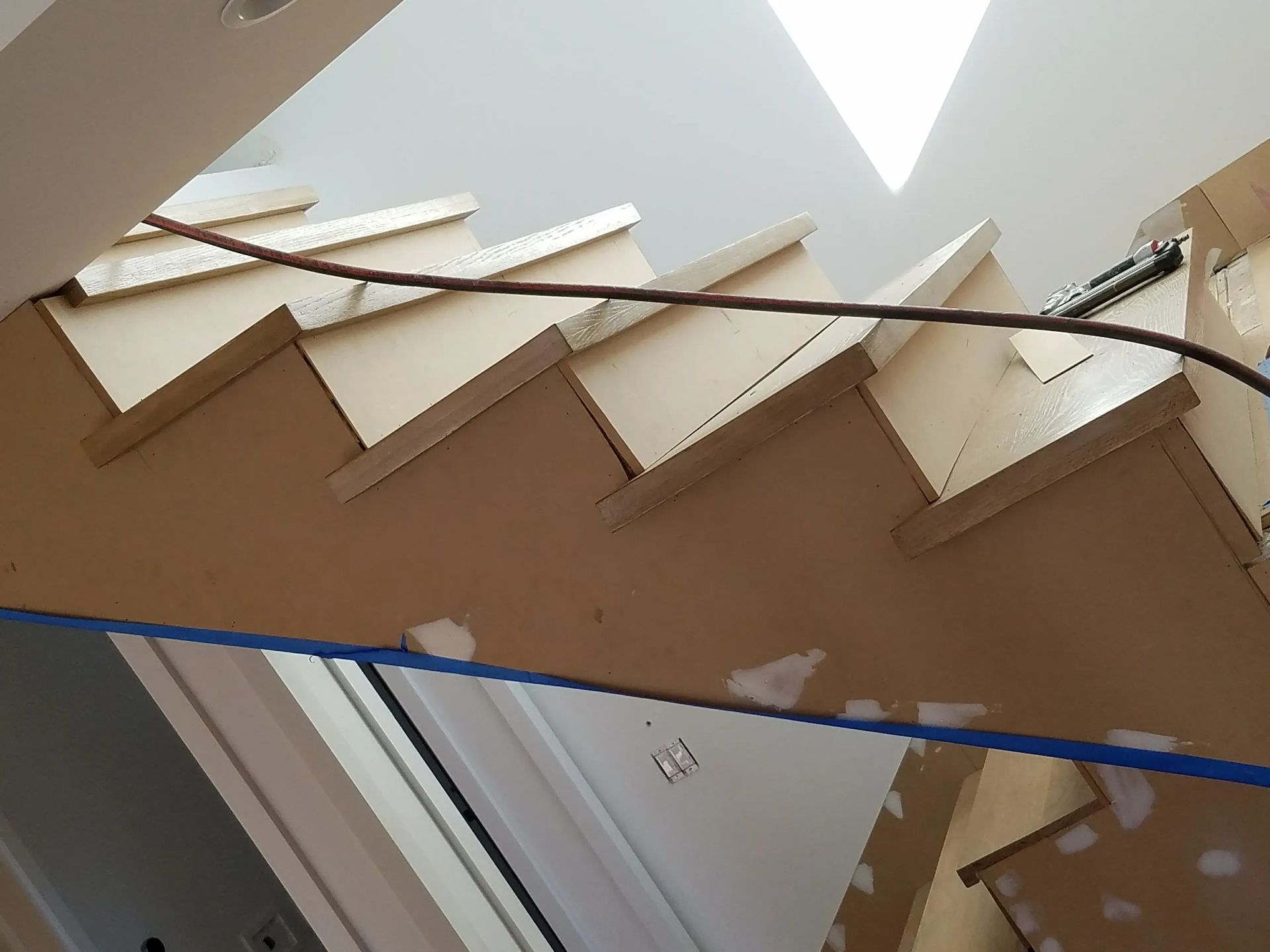 A wooden staircase is being built in a house