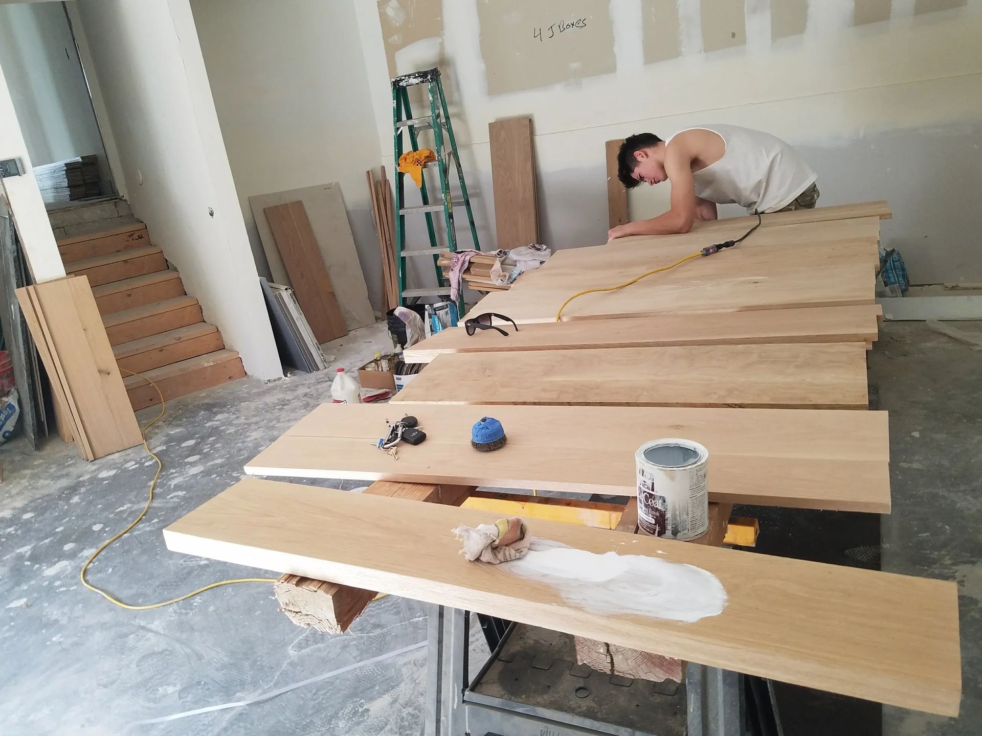 A man is working on a wooden table in a room