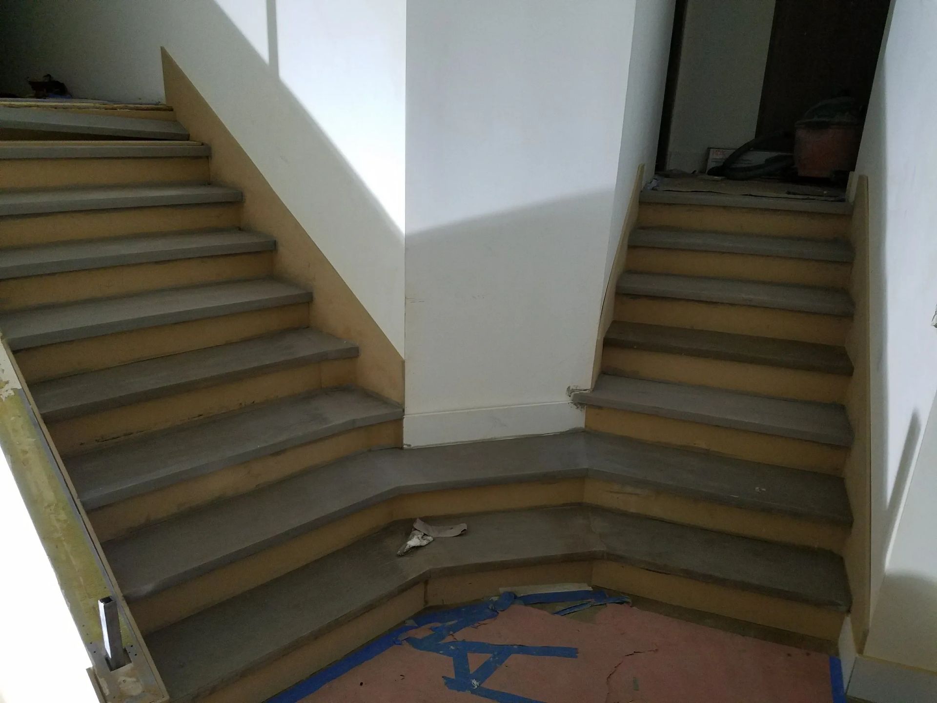 A set of stairs in a building with a blue tape on the floor