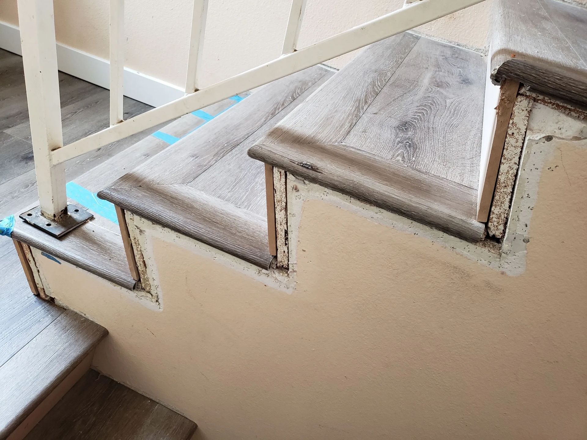 A close up of a staircase with wooden steps and a white railing