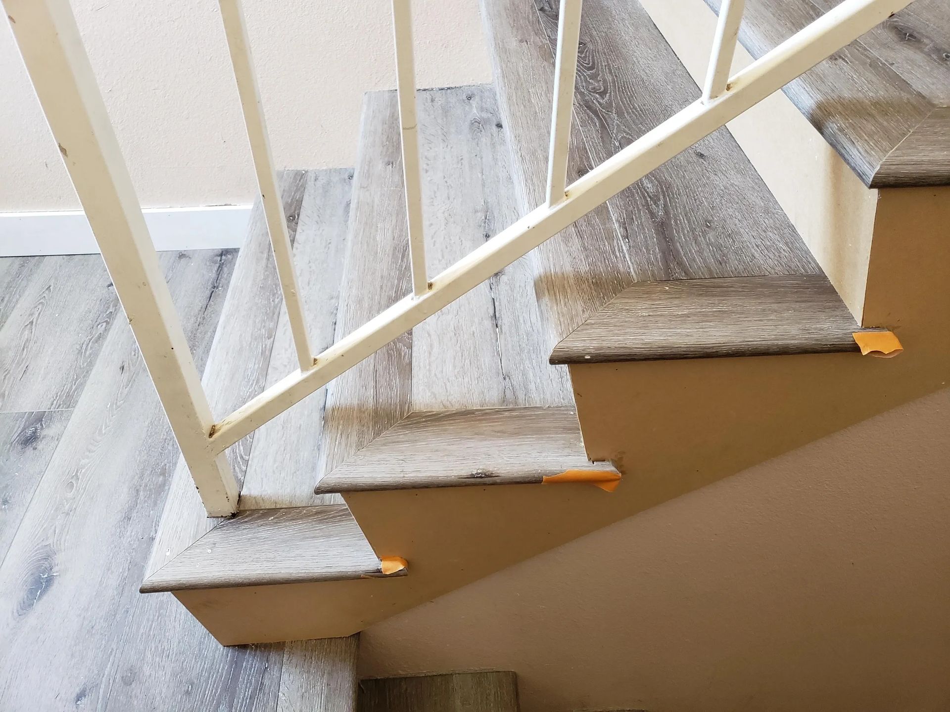 A close up of a staircase with wooden steps and a white railing
