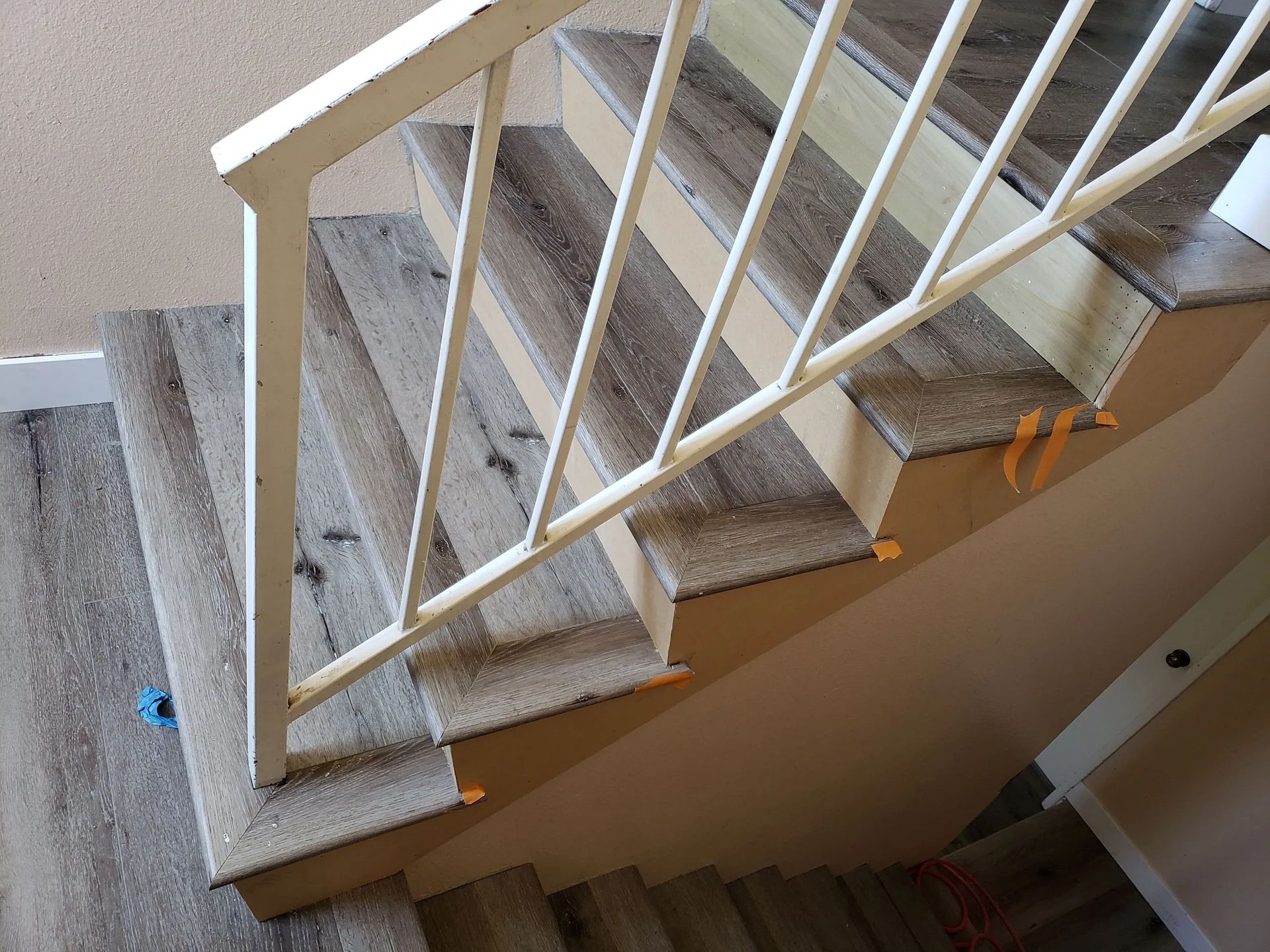 A staircase with a white railing and carpeted steps