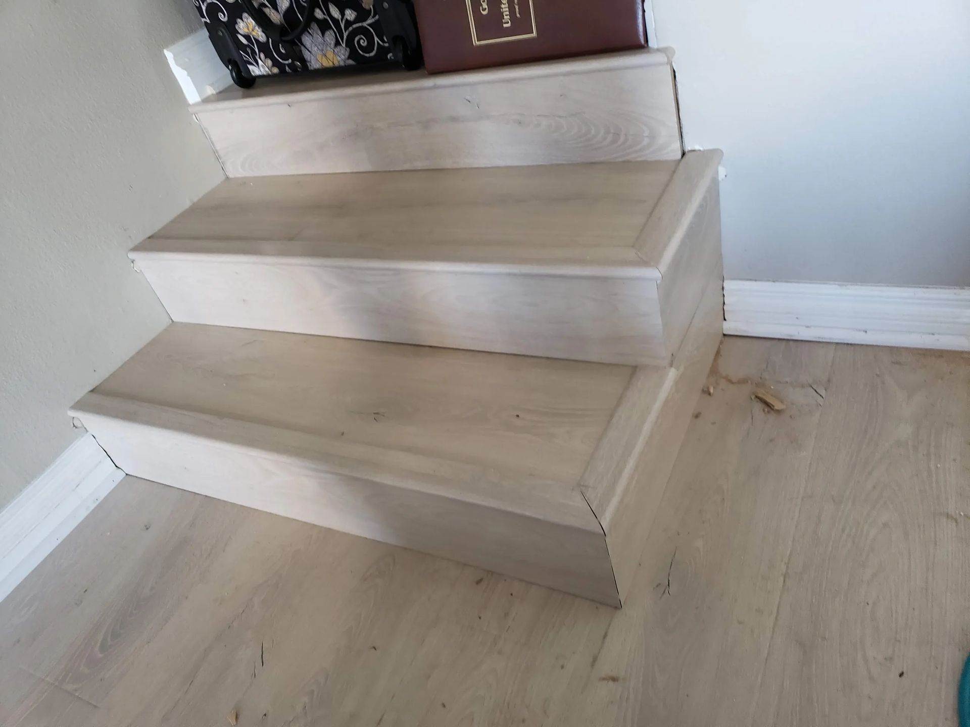 A set of wooden stairs with a bag on top of them