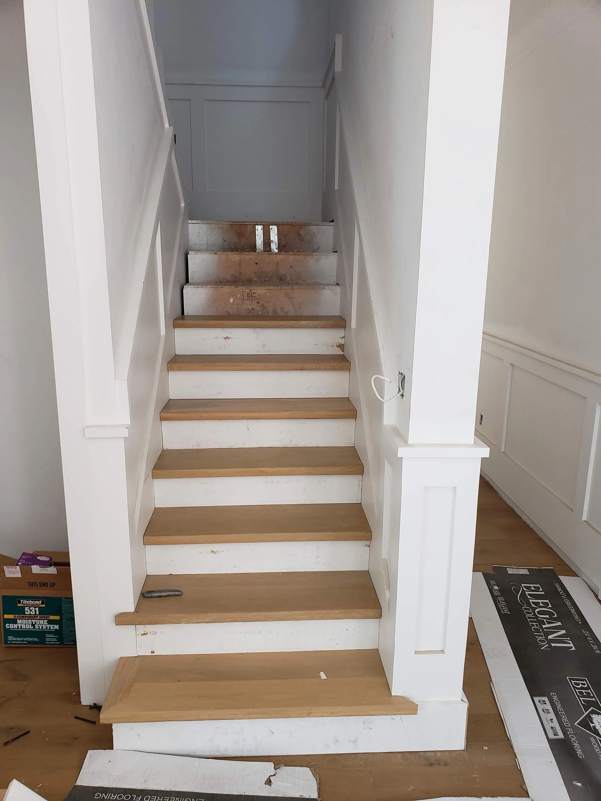 A white staircase with wooden steps and a white railing