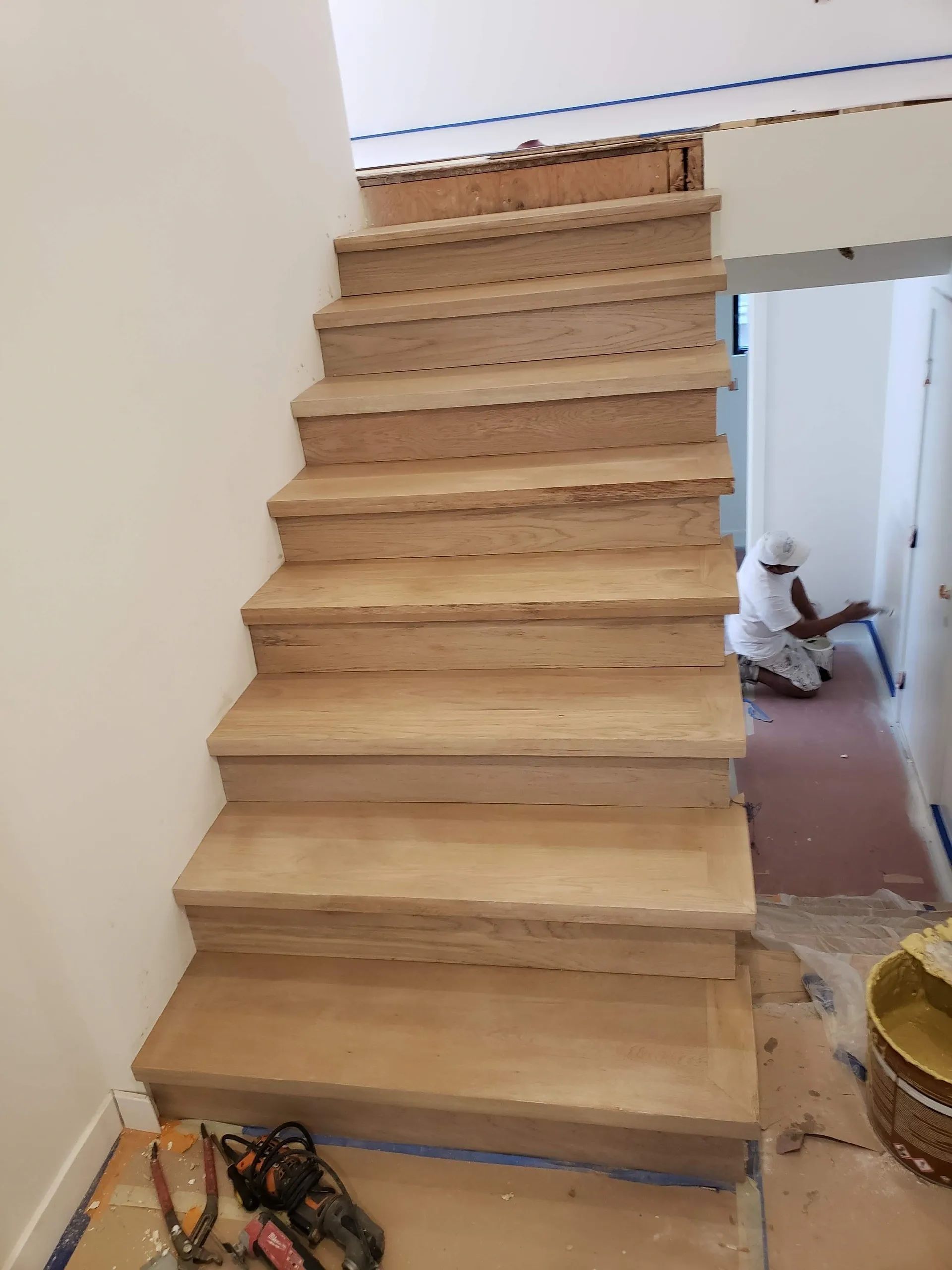 A man is painting a staircase with a vacuum cleaner