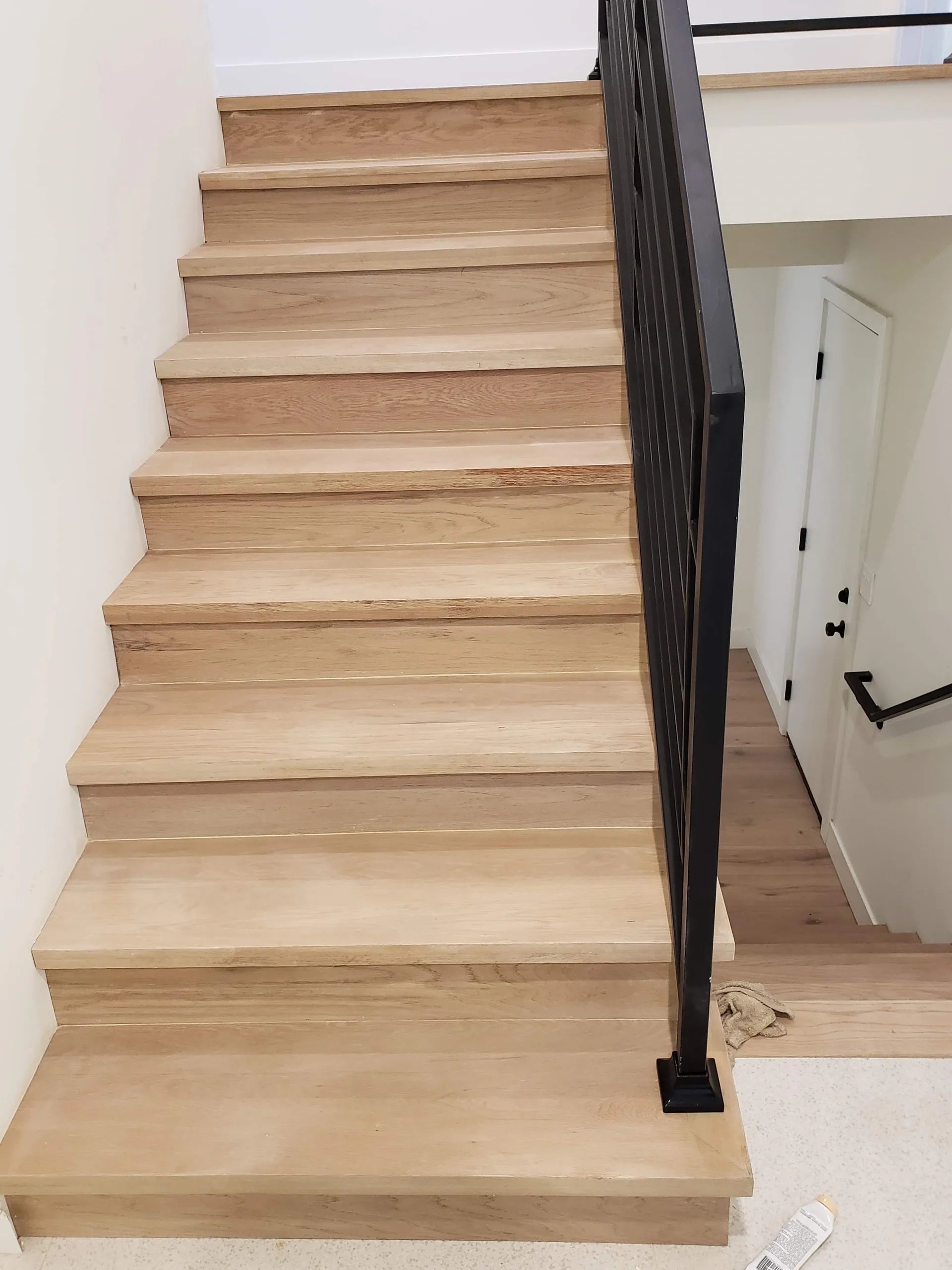A wooden staircase with a metal railing in a room