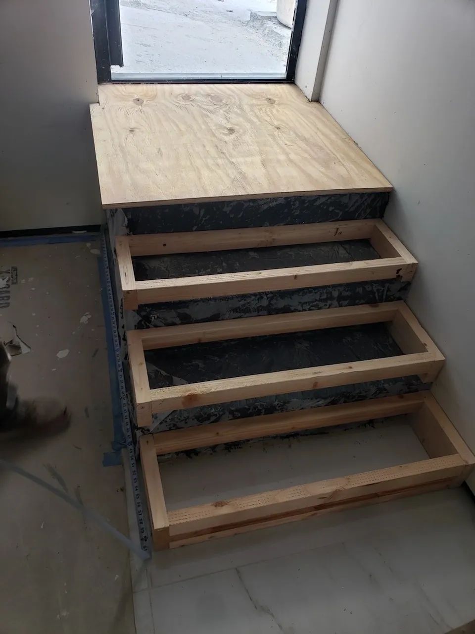 A set of wooden stairs being built in a room