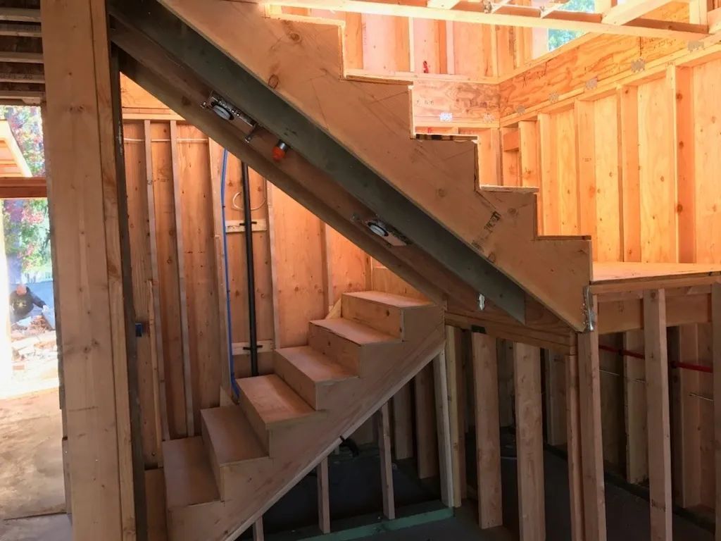 A wooden staircase is being built in a house