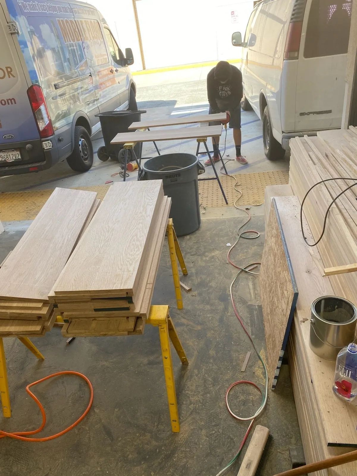 A man is working on a wooden table in a garage