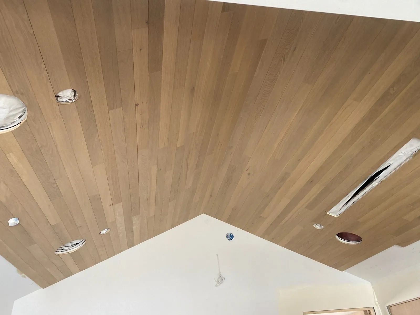 A room with a wooden ceiling and a white wall