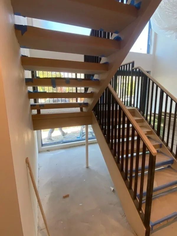 A wooden staircase with a black railing in a building