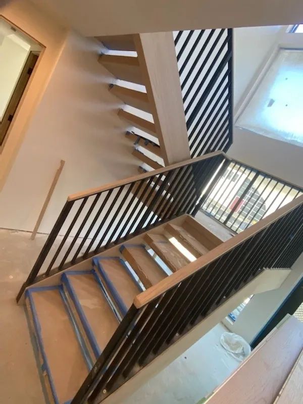 A staircase with a black railing and wooden steps