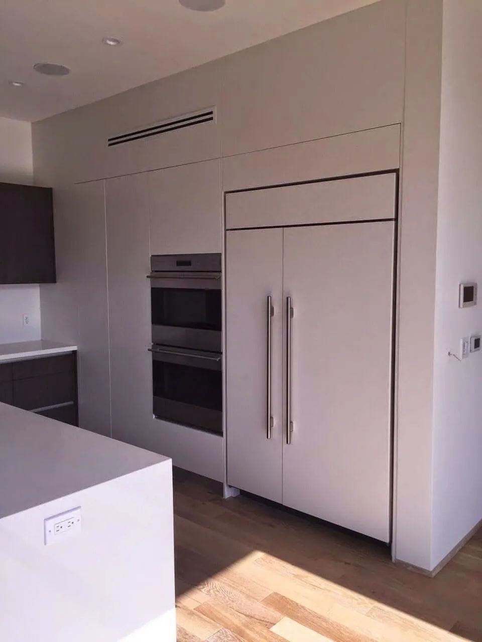 A kitchen with white cabinets and a stainless steel oven