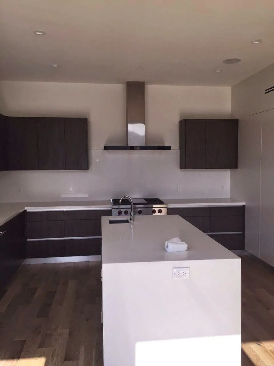A kitchen with a large island and a stove top oven