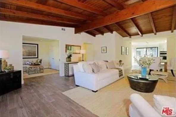 A living room with a wooden ceiling and a white couch