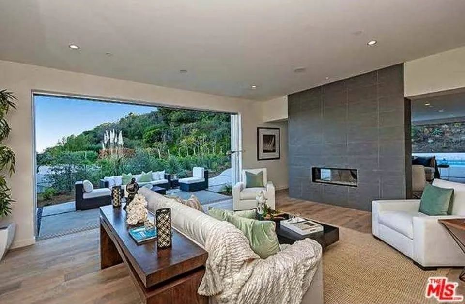 A living room with a couch and chairs and a fireplace