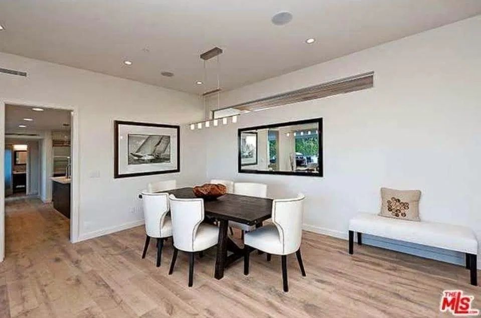 A dining room with a table and chairs and a bench