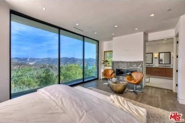 A bedroom with a large window and a bed