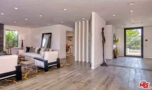 A living room with a couch , chairs , and a mirror