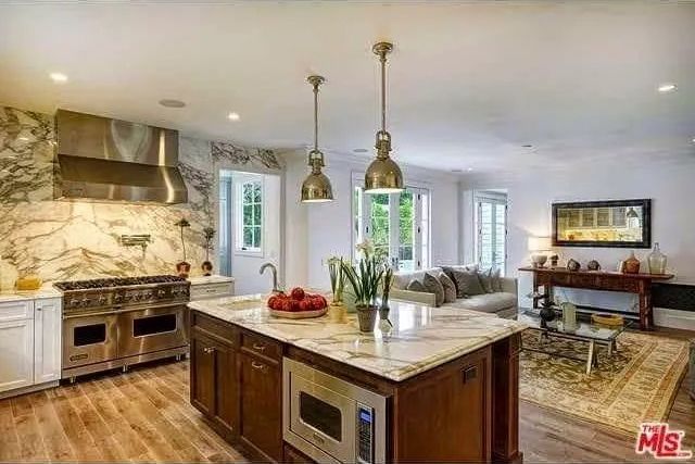 A kitchen with a large island and stainless steel appliances