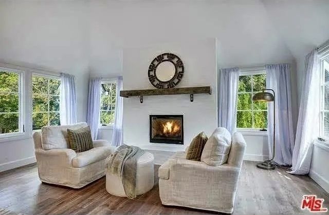 There is a fireplace in the middle of the living room