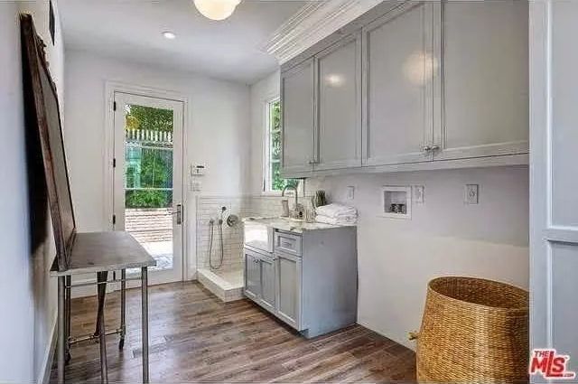 A laundry room with a sink , cabinets , and a basket