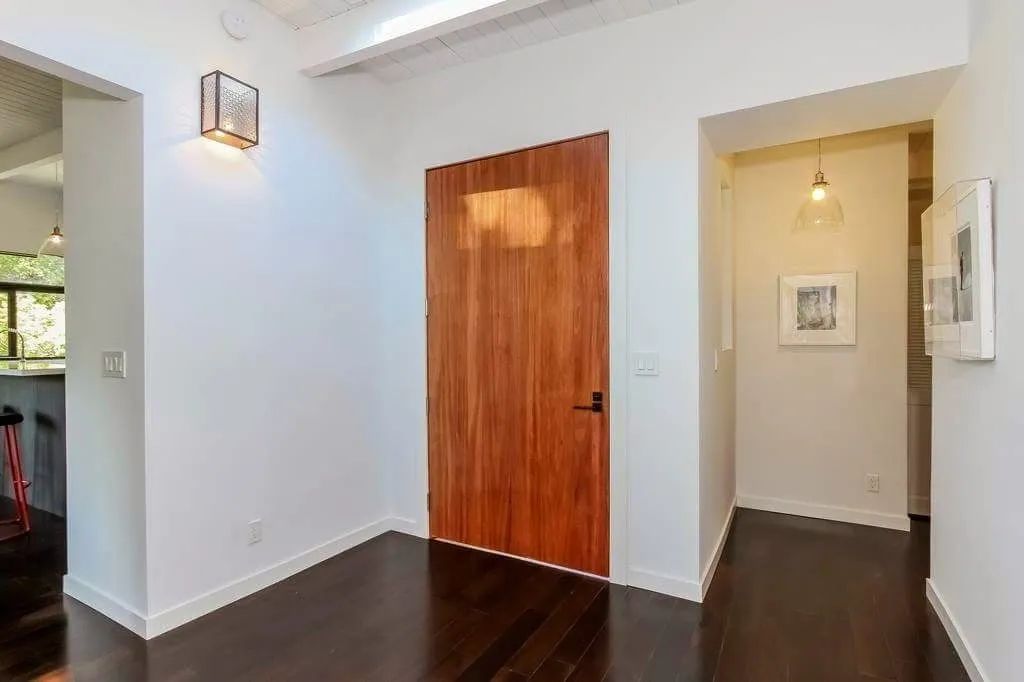 There is a wooden door in the middle of the hallway