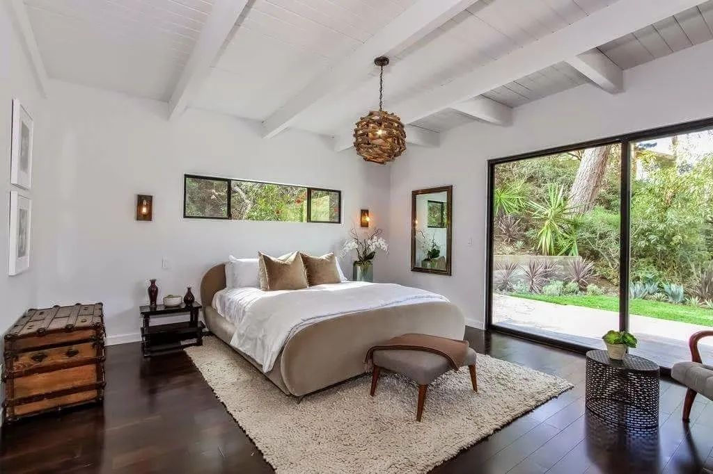 A bedroom with a large bed and sliding glass doors