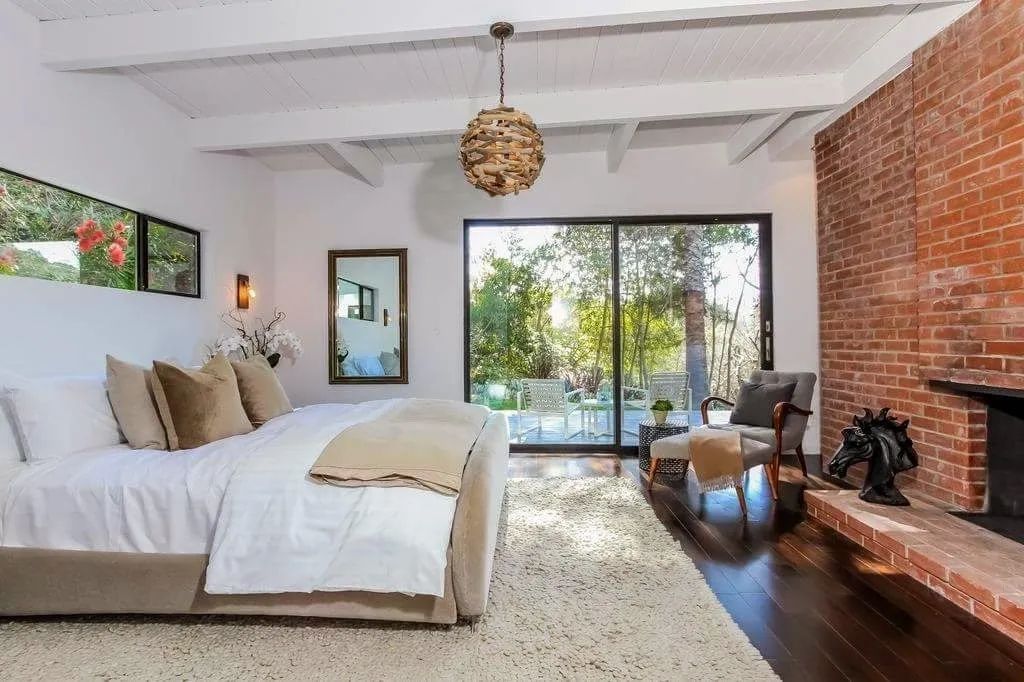 A bedroom with a large bed and a fireplace