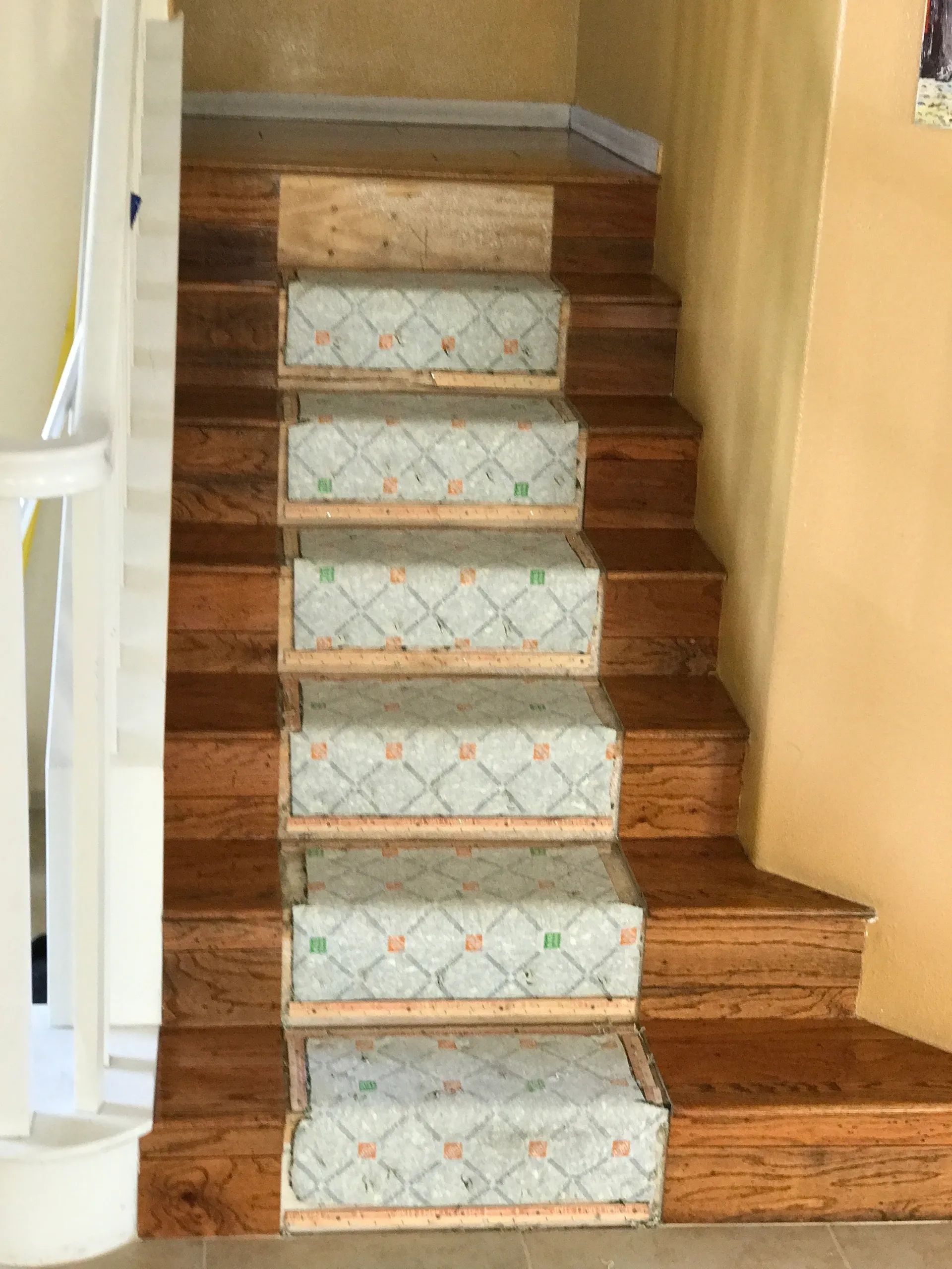 A wooden staircase with a patterned carpet on the steps