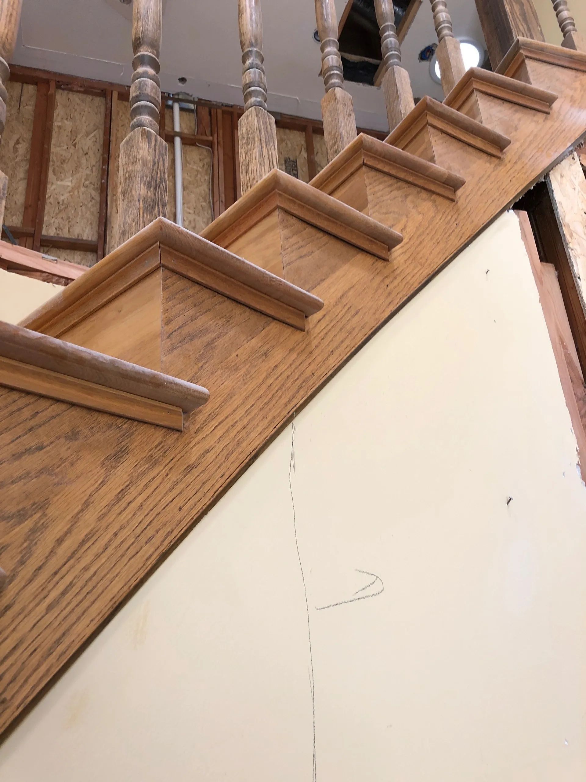 A wooden staircase is being built in a house