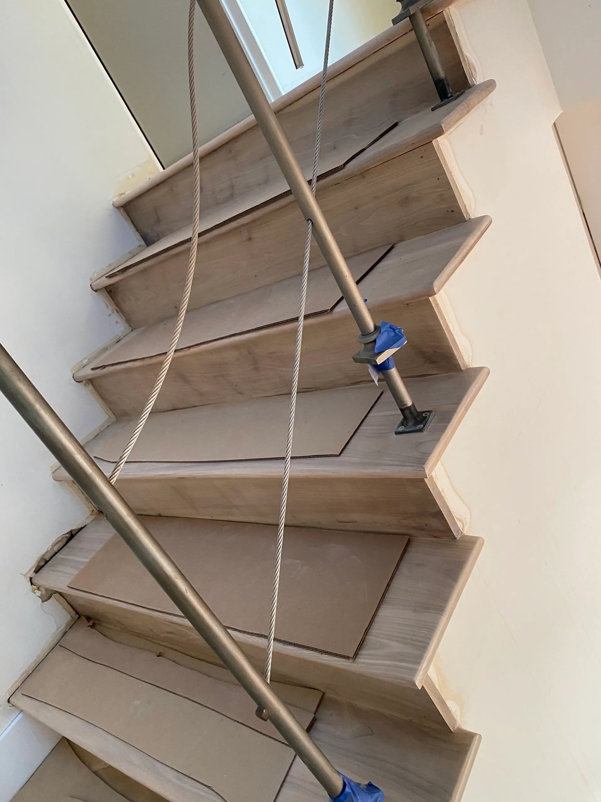 A set of wooden stairs with a metal railing