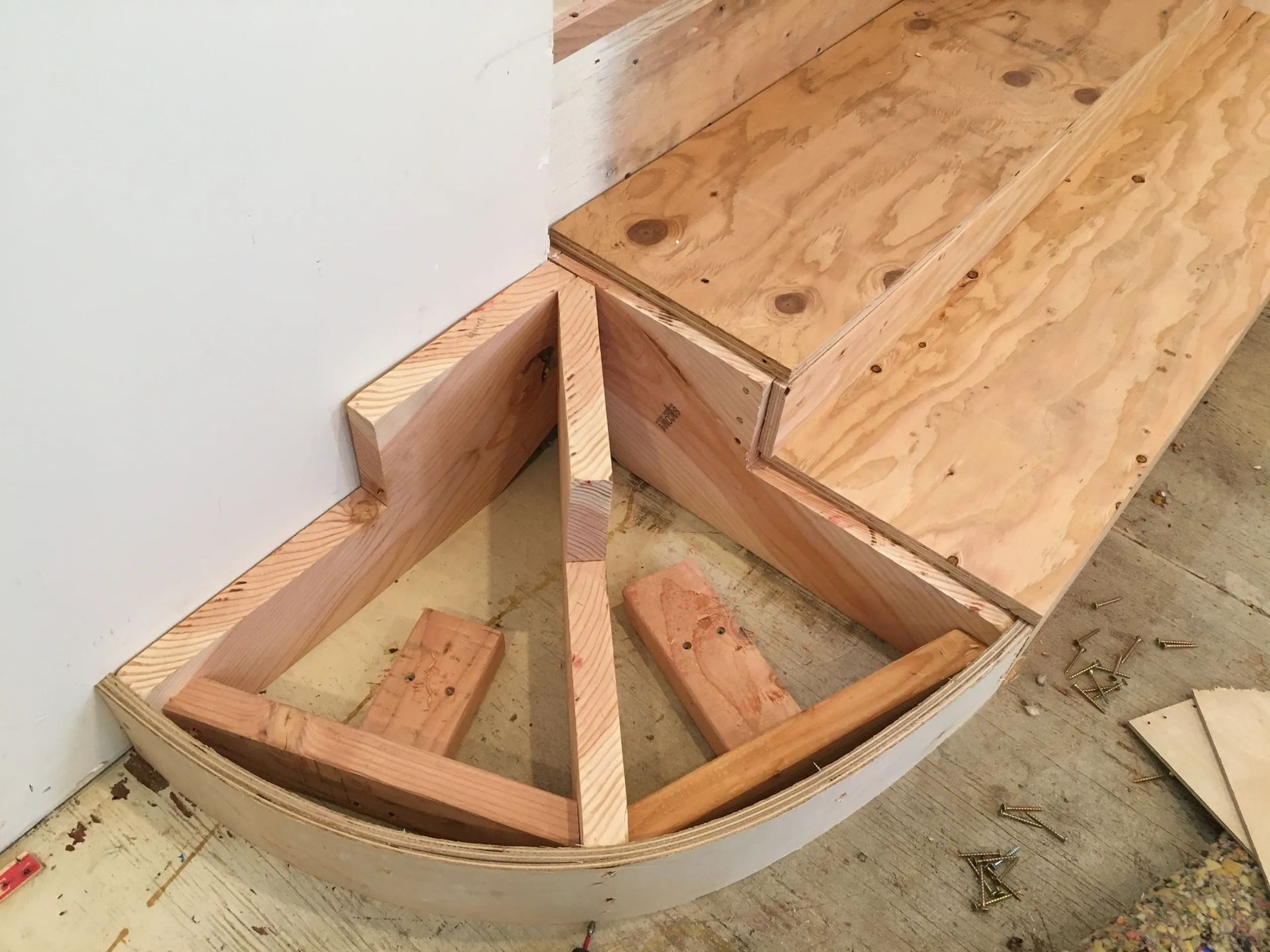 A wooden staircase is being built in a room