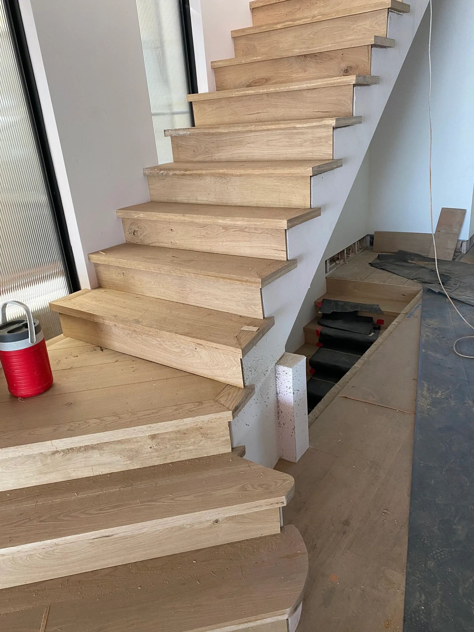 A wooden staircase is being built in a house