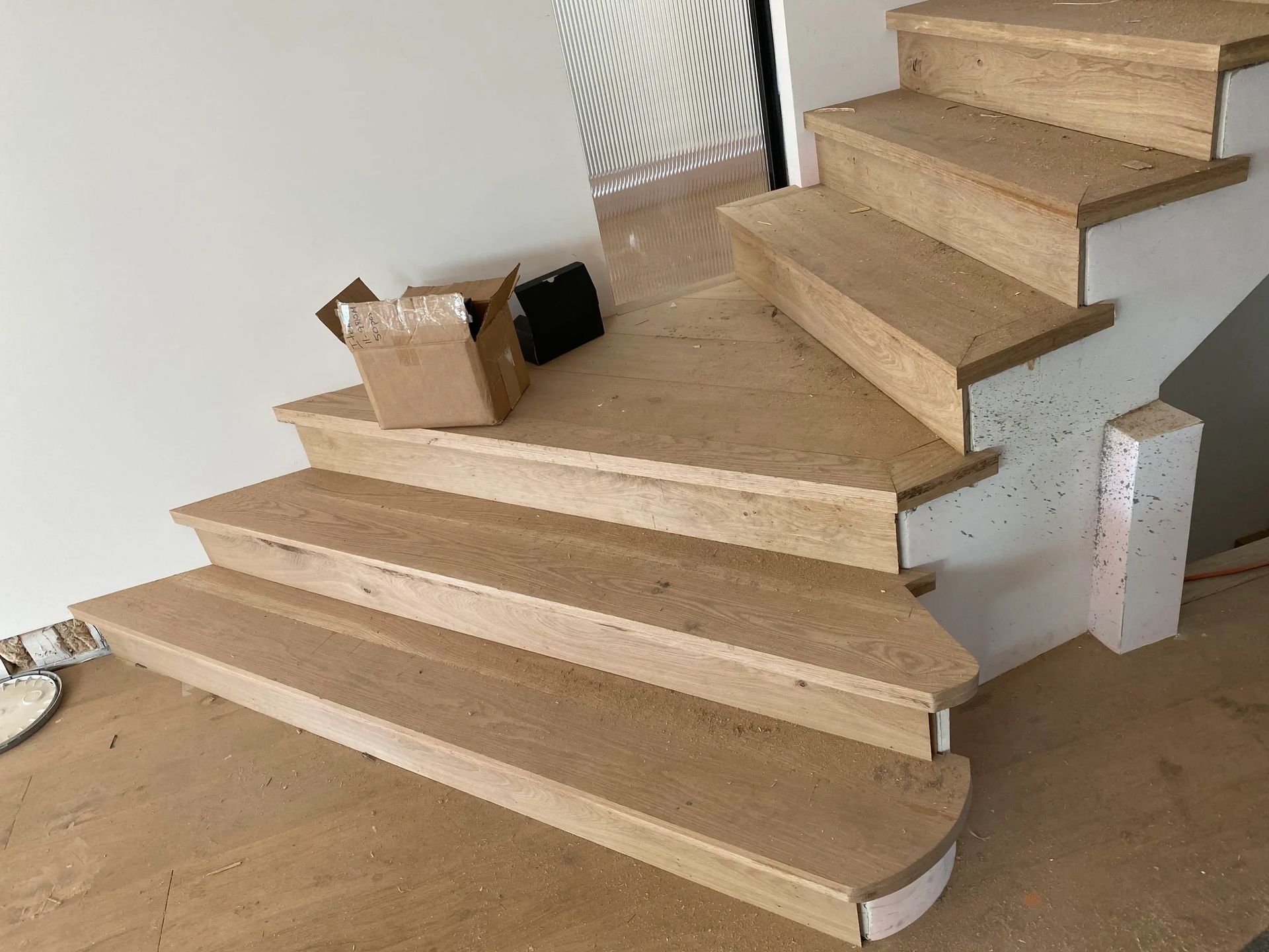 A wooden staircase is being built in a house